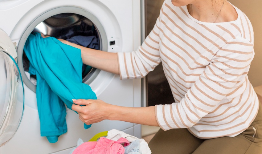 woman-pulling-clothes-from-washing-machine